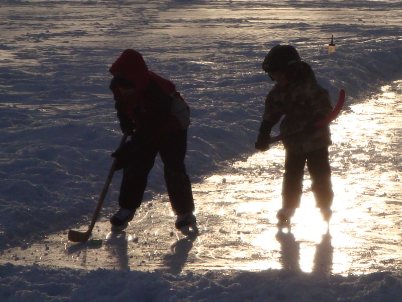 Children playing ice hockey on outdoor rink