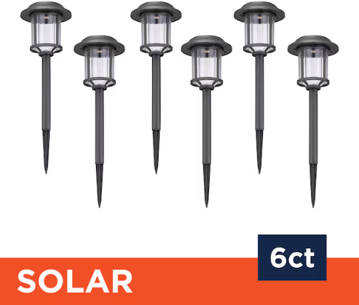 Harbor Breeze 6-pack matte black solar LED outdoor path lights displayed in a garden setting at Lowe