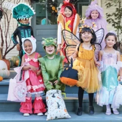 Children in Halloween costumes on a porch at a Pottery Barn Kids Halloween craft event